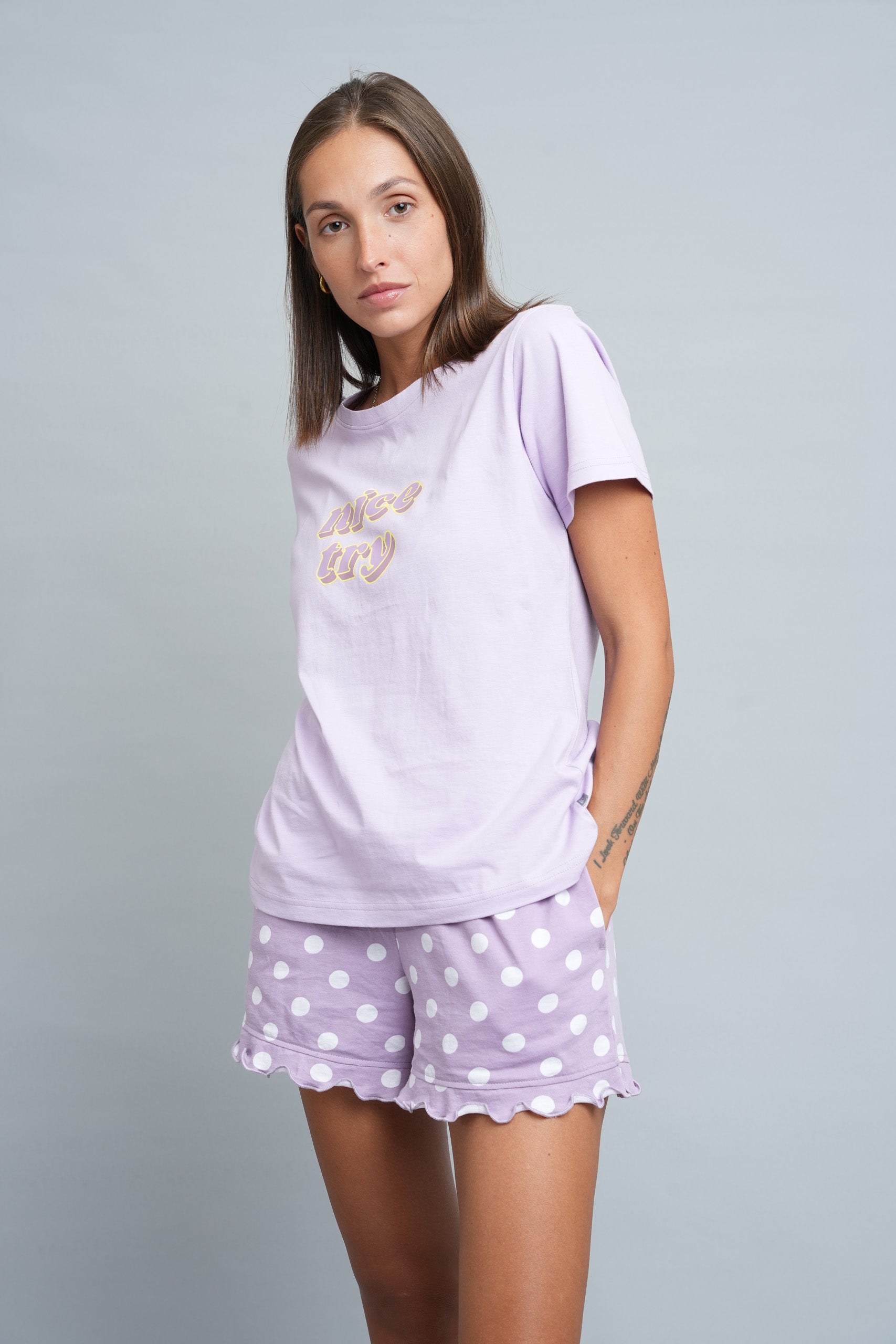 dorable purple pajama shorts set with a plain top and patterned shorts, featuring a playful front rubber print and a frilly hem.